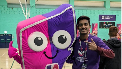 Stuident standing with a mascot